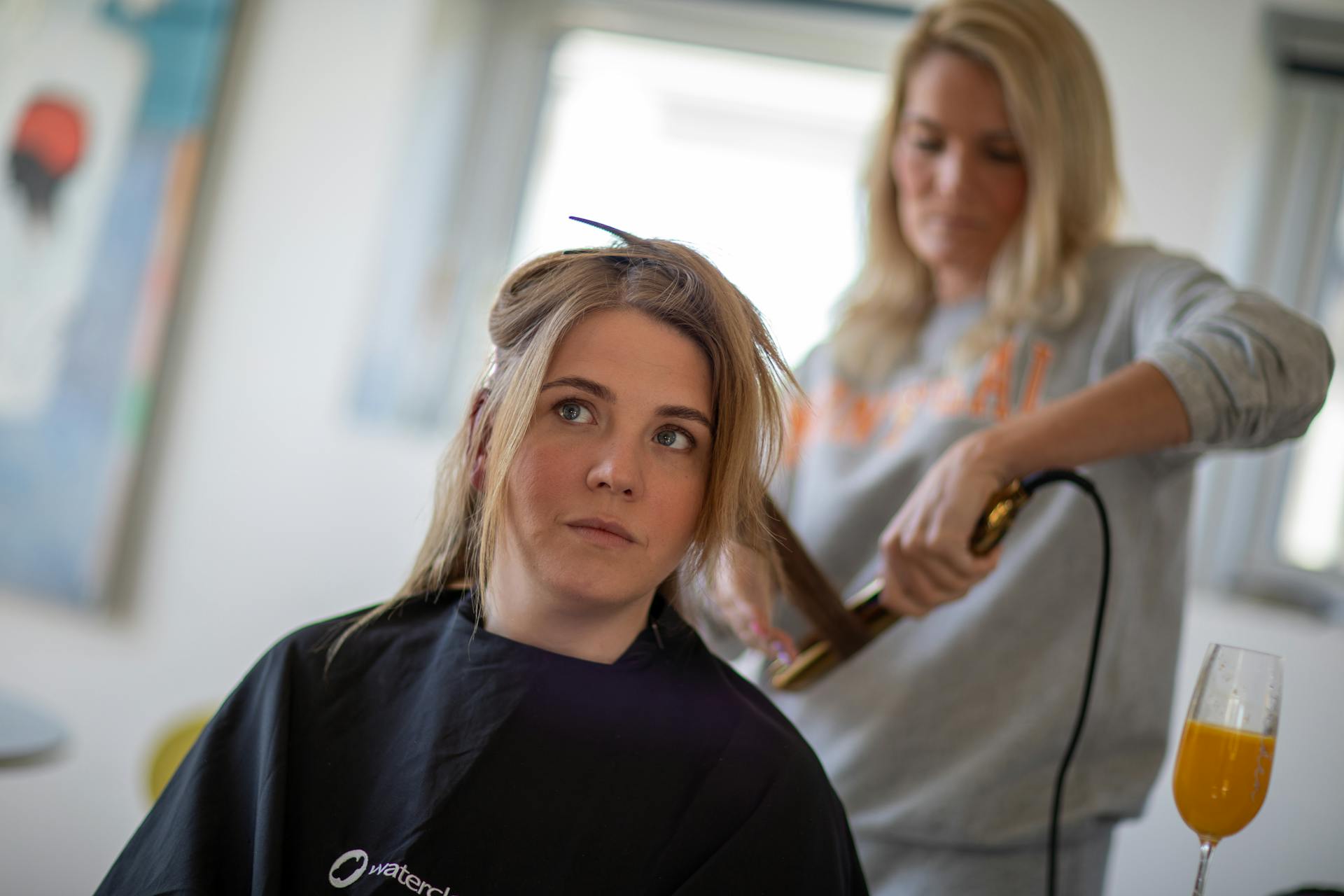 Estudiante de R&C Beauty College peinando a una clienta en el salón estudiantil