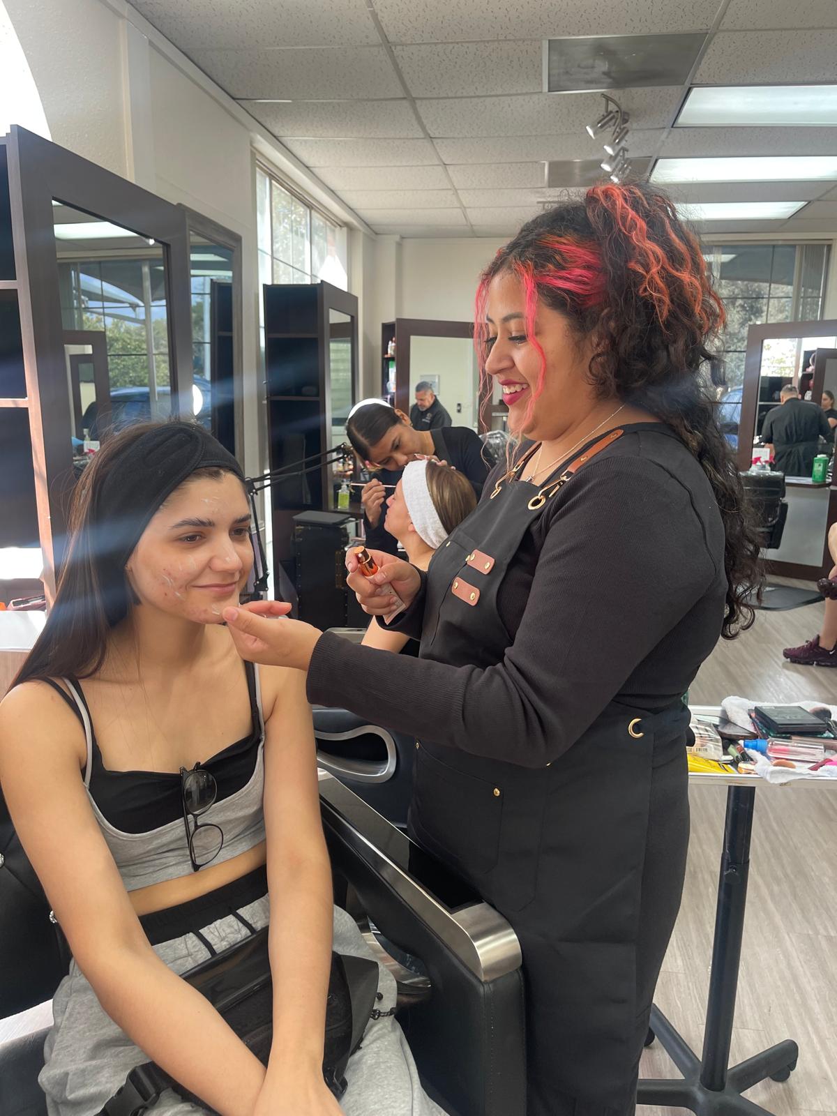 Instructora y estudiante trabajando con una clienta en R&C Beauty College